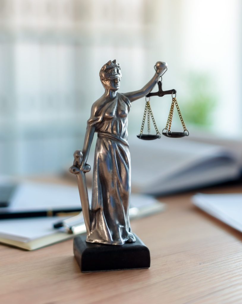 Lady Justice statue in law firm attorney office, blindfolded Justitia with balance scales and sword is personification of moral force in judicial system