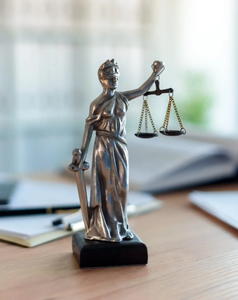 Lady Justice statue in law firm attorney office, blindfolded Justitia with balance scales and sword is personification of moral force in judicial system